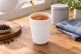 Tea poured into the tall white banded teacup