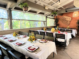 Mocha Stackable Indoor/Outdoor Chair with Black Aluminum Frame in a restaurant setting; other furniture is illustrative