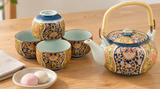 NT8-NK ornate teapot and four cups in original arrangement beside a separate dish of two mochi and linen