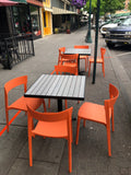Orange open-back plastic restaurant chair; restaurant setting, other furniture illustrative