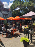 Orange open-back plastic restaurant chair; restaurant setting, other furniture illustrative