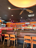 Orange plastic restaurant chair; restaurant setting, other furniture illustrative