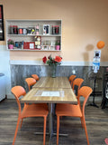 Orange plastic restaurant chair; restaurant setting, other furniture illustrative