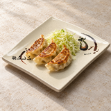 508-E Eggplant-pattern melamine plate — Three gyoza and a small mound of shredded cabbage across center on a pale stone table