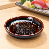 1703TM Tenmoku shallow round sauce dish with soy sauce beside a sushi setting