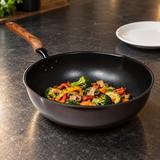 12.60" Aluminum Stir-Fry Pan with Wood Handle with a finished food preparation