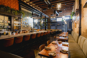Pumpkin Upholstered Restaurant Barstool with Wood-Grain Metal Frame in a restaurant setting; other furniture is illustrative