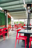 Red open-back plastic restaurant chair; restaurant setting, other furniture illustrative