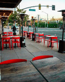 Red open-back plastic restaurant chair; restaurant setting, other furniture illustrative