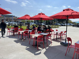 Red plastic restaurant chair; restaurant setting, other furniture illustrative