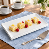 SA008-01 white rectangular platter with four lemon cake portions and raspberries beside coffee and a cake server