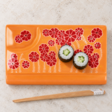 Orange floral rectangular ceramic sushi plate with cucumber maki and chopsticks
