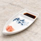 10-BZ white boat-shaped dish with blue bamboo pattern with soy sauce and ginger on a stone tabletop