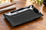 24120BK black melamine plate on a wooden restaurant table
