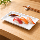 A0406 white two-compartment lotus-rim ceramic plate with nigiri on a wooden restaurant table