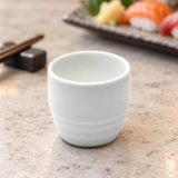 A1888 white ceramic sake cup in a stone tabletop sushi setting