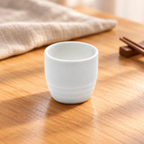 A1888 white ceramic sake cup on a wooden restaurant table