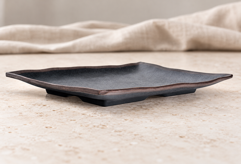IT-F54115TM irregular-edged Tenmoku plate on a wooden table