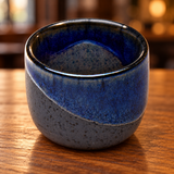 JX8-2 blue diagonal-glaze sake cup on a wooden restaurant table