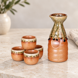 JX9-7 sake set with one bottle and four cups on a pale countertop