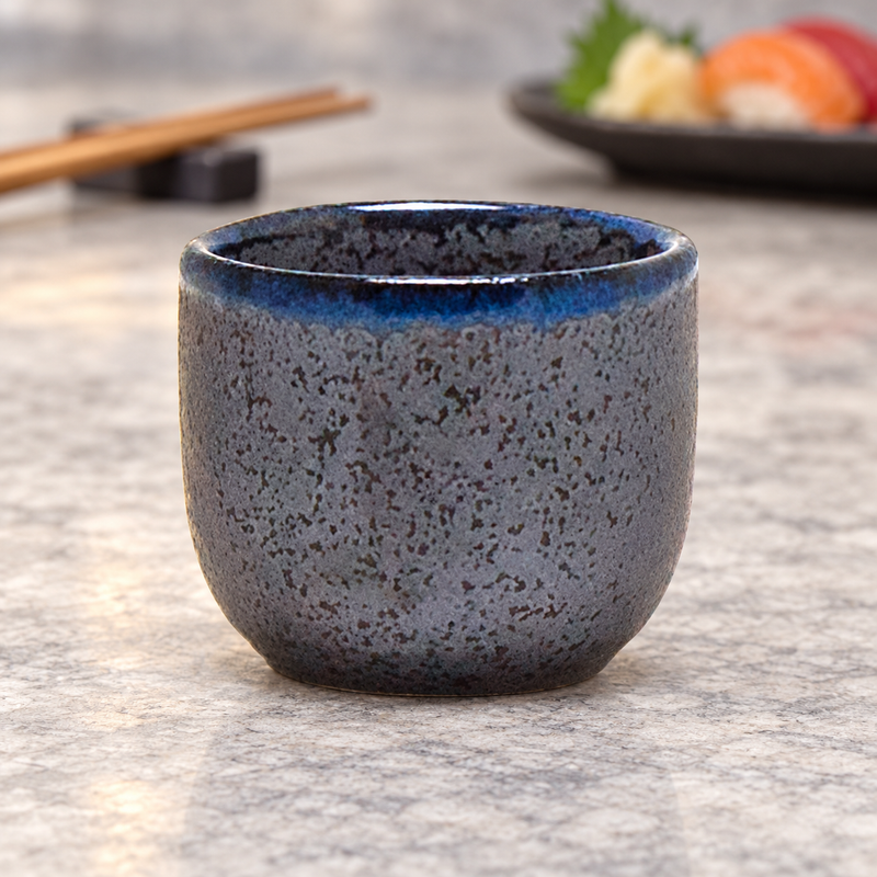 KY8-BK stony-black sake cup beside a sushi table setting