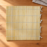 SM2495 bamboo sushi mat shown empty on a wooden preparation counter