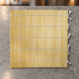 SM2495 bamboo sushi mat shown empty on a stone counter