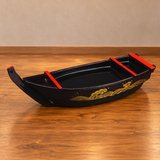 WM874 dark burgundy sushi boat with red trim and gold wave ornament on a wooden restaurant counter