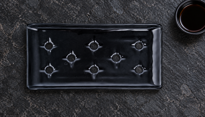 Black KM5924-B porcelain case plate in a tabletop display setting, preserving its eight shaped openings