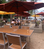 Teak-Look Stackable Indoor/Outdoor Chair with Silver Aluminum Frame in a restaurant setting; other furniture is illustrative