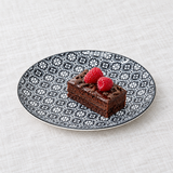 TN281-BK black geometric floral plate with a small cake serving