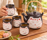Dark smiling-cat tea set with four cups during shared service