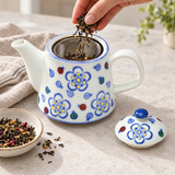 TPS2-1076 floral teapot with loose tea being added to its mesh basket