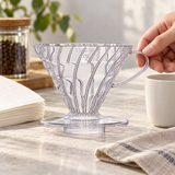 Transparent HARIO V60 02 dripper being positioned before coffee preparation