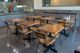 Walnut solid ashwood seat and back restaurant chair with metal frame; restaurant setting with other furniture illustrative
