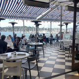 White open-back plastic restaurant chair; restaurant setting, other furniture illustrative
