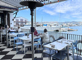 White open-back plastic restaurant chair; restaurant setting, other furniture illustrative