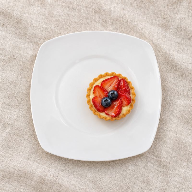 White rounded-square ceramic plate with fruit tart