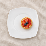 White rounded-square ceramic plate with fruit tart