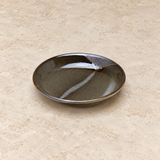 Ceramic serving dish on a neutral stone tabletop, same-view context