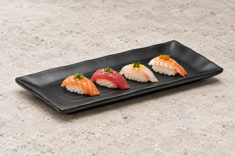 YG-5011MB matte-black plate with a nigiri assortment on a stone tabletop