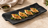 YG-5414MB matte black rectangular platter with four gyoza and scallions