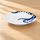Blue octopus-design ceramic plate on a wood tabletop