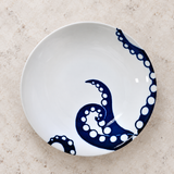 Blue octopus-design ceramic plate on a stone tabletop