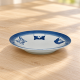 Blue cat-design ceramic plate on a wood tabletop