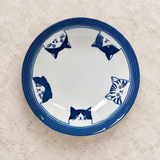 Blue cat-design ceramic plate on a stone tabletop
