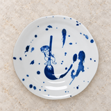 Blue cat-design ceramic plate on a stone tabletop