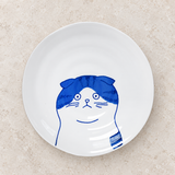 Blue cat-design ceramic plate on a stone tabletop