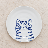 Blue cat-design ceramic plate on a stone tabletop