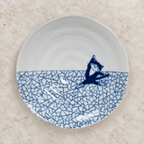 Blue cat-design ceramic plate on a stone tabletop